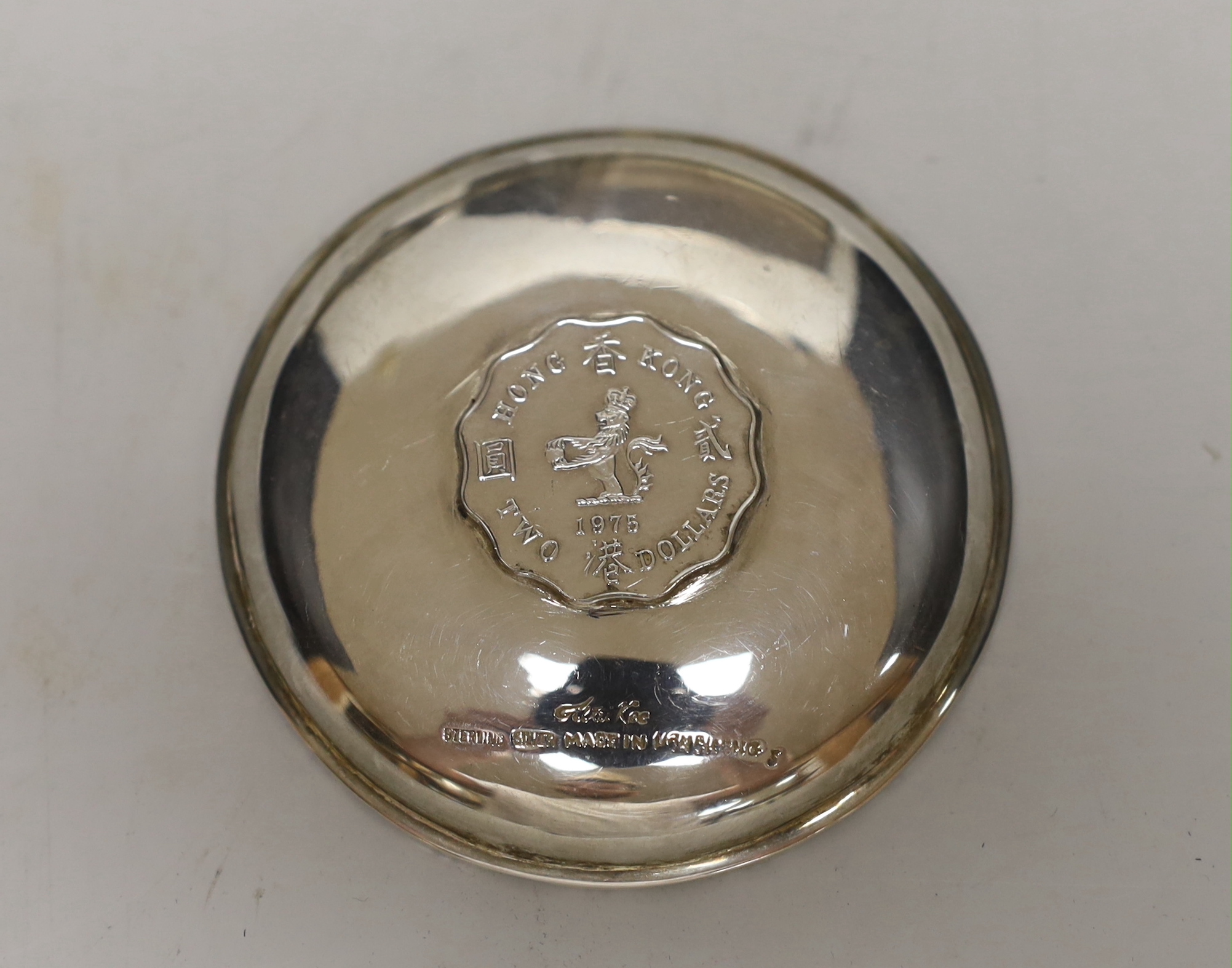 A George V engine turned silver cigarette case, 11.3cm a white metal sauceboat and a Wai Kee sterling pin dish.